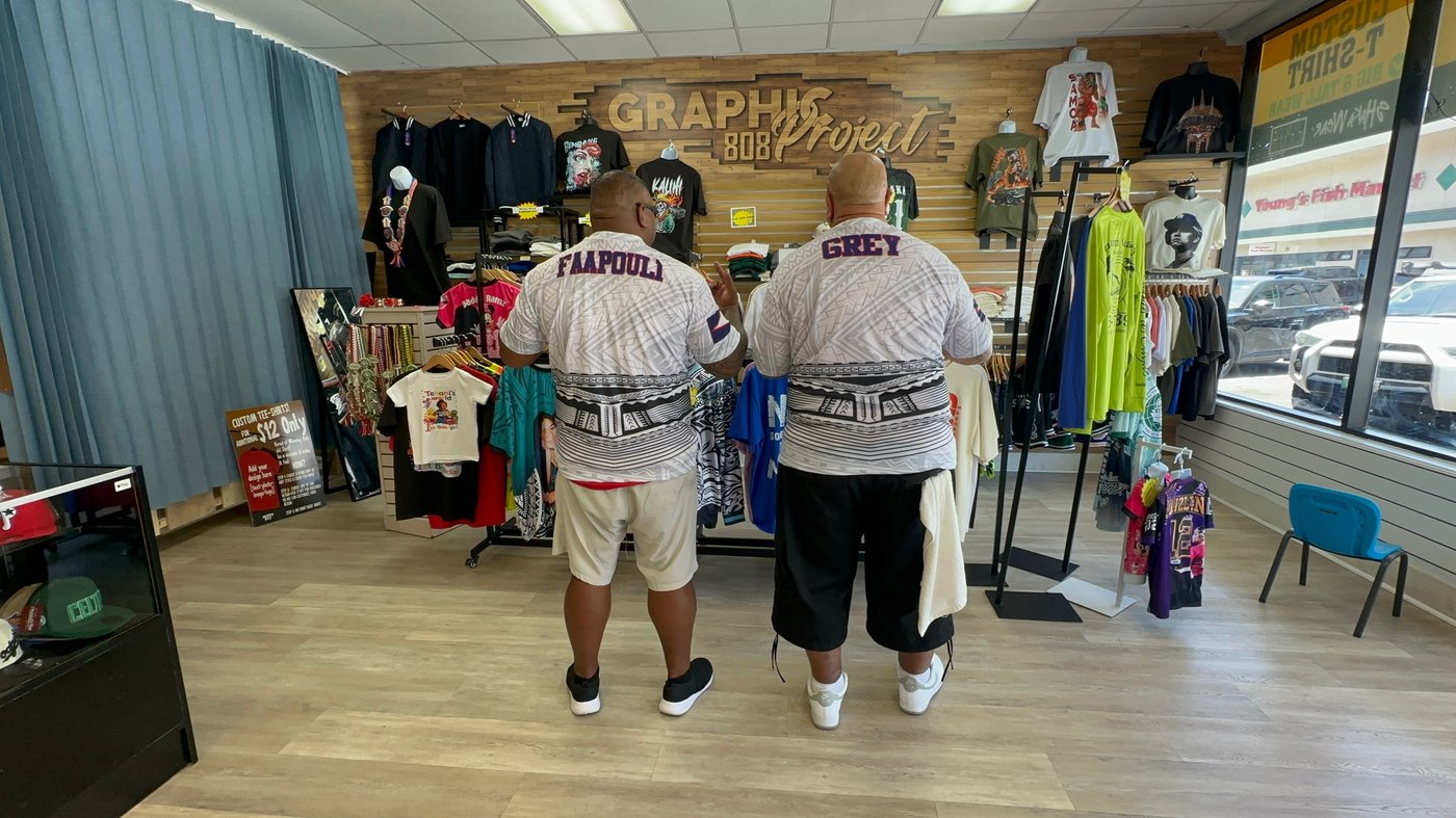 Two customers wearing custom tribal-print jerseys made at Graphic Project 808